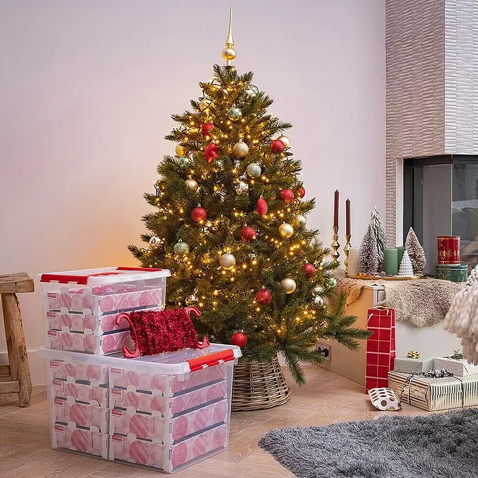 Sunware Aufbewahrungsbox Q-Line für Weihnachtskugeln - Passend für: 60 Christbaumkugeln (Ø 45 - 60 mm), L x B x H: 40 x 30 x 29 cm, Kunststoff, Transparent - Aufbewahrungsboxen mit roten Deckeln, gestapelt vor einem festlich geschmückten Weihnachtsbaum. Ideal für die Lagerung von Weihnachtsschmuck!