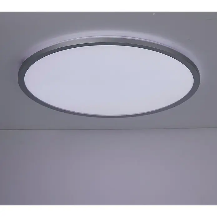 Brilliant LED-Deckenleuchte rund Tanida - 46 W, Ø x H: 57 x 3,2 cm, Silber, RGBW - Nahaufnahme einer runden Deckenleuchte mit silberfarbenem Rahmen und weißem Diffusor, die helles Licht in einem modernen Raum spendet.