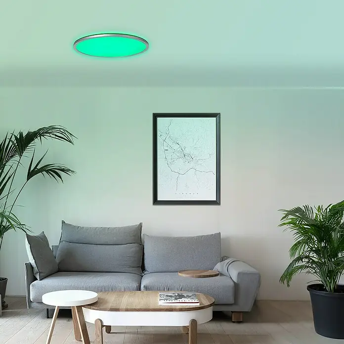 Brilliant LED-Deckenleuchte rund Tanida - 46 W, Ø x H: 57 x 3,2 cm, Silber, RGBW - Eine moderne Deckenleuchte mit grüner Beleuchtung in einem stilvollen Wohnzimmer. Die Lampe sorgt für ein angenehmes Ambiente im Raum.