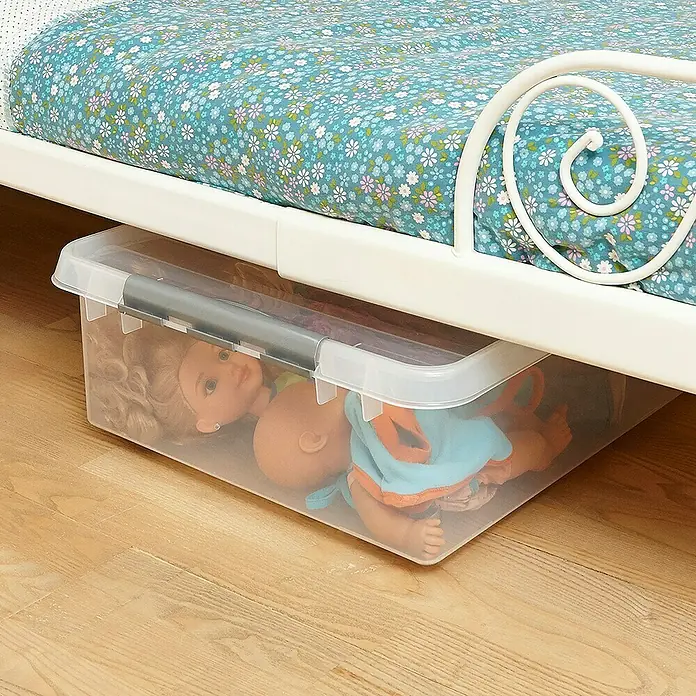 Sunware Aufbewahrungsbox Q-Line mit Rollen - L x B x H: 80 x 50 x 20 cm, Kunststoff, Transparent - Ein durchsichtiger Aufbewahrungsbehälter mit Puppen darunter einem Bett mit blau-weißem Blumenmuster und weißem Rahmen.