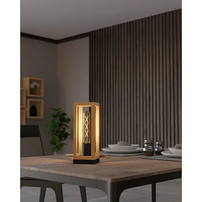 Eglo Nafferton Lámpara de sobremesa - 40 W, L x An x Al: 10 x 10 x 28 cm, Negro y Madera - Primer plano de una lámpara de mesa moderna con elementos de madera y una bombilla decorativa sobre una mesa de comedor.