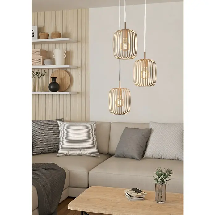 Eglo Romazzina Pendelleuchte - 120 W, Ø x H: 46 x 110 cm, Sand, E27 - Nahaufnahme von drei dekorativen Pendelleuchten aus Holz, die über einem Sofa hängen und warmes Licht in einem Wohnzimmer verbreiten.