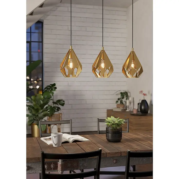 Eglo Lámpara colgante Carlton - 180 W, L x An x Al: 20,5 x 80,5 x 110 cm, Dorado, E27 - Tres lámparas colgantes doradas cuelgan sobre una mesa de comedor, iluminando la habitación con su cálido resplandor.