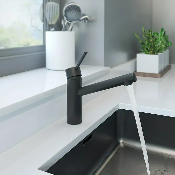 Lenz Spültischarmatur Ira - Schwarz, Matt - Nahaufnahme eines eleganten, mattschwarzen Wasserhahns, der Wasser in ein Edelstahlspülbecken leitet, mit einer minimalistischen Küchenumgebung.