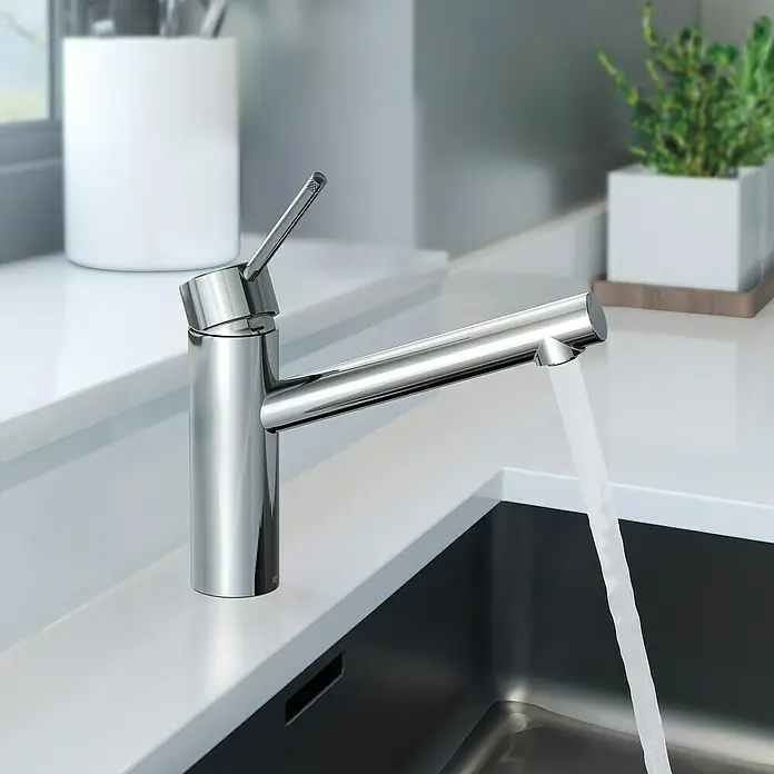 Lenz Spültischarmatur Ira - Chrom, Glänzend - Nahaufnahme eines modernen, verchromten Wasserhahns mit fließendem Wasser in einer stilvollen Küche.