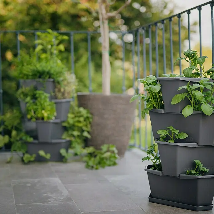 Gusta Garden Pflanzturm Paul Potato - 44 x 44 x 65 cm, Anthrazit - Der graue, mehrstöckige Pflanzkasten ist mit grünen Pflanzen bepflanzt und steht auf einer Terrasse. Ideal für kleine Gärten oder Balkone.