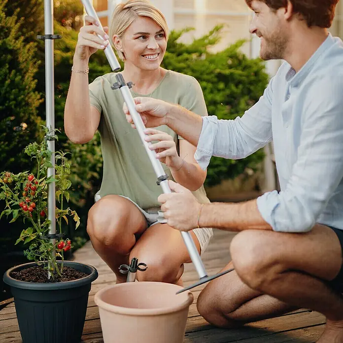 Gusta Garden Rankhilfe Tomato Buddy - Länge: 125 cm, 1 Stk. - Ein Paar montiert eine Tomatenstütze im Garten, die eine ideale Unterstützung für wachsende Tomatenpflanzen bietet.