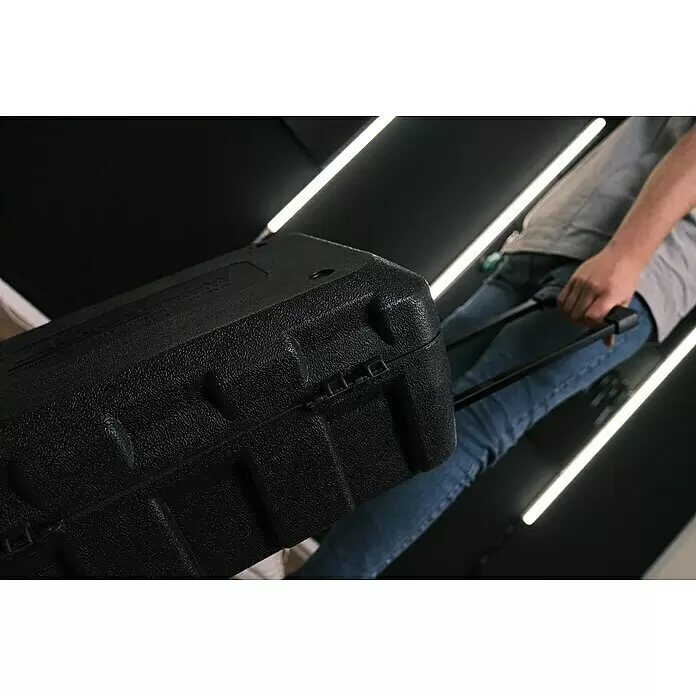Brüder Mannesmann Maletín de herramientas Green Line - 122 pzs. - Maleta rígida negra y texturizada, siendo arrastrada por una persona, con asa retráctil.