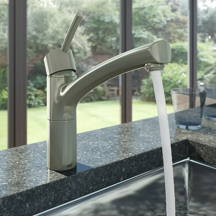 Lenz Spültischarmatur Nexo 2 - Nickel, Matt, Mit Handbrause - Nahaufnahme einer modernen Küchenarmatur aus Metall, die Wasser in ein Spülbecken abgibt, mit einem Fenster im Hintergrund.
