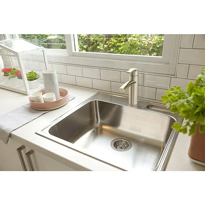 Lenz Spültischarmatur Kimo - Nickel, Matt - Nahaufnahme eines Edelstahlspülbeckens mit Armatur, das in eine helle Küchentheke eingelassen ist und modernes Design zeigt.