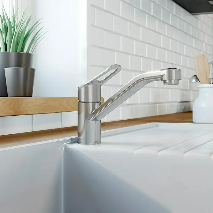 Lenz Spültischarmatur Mila - Edelstahl, Matt, Höhe: 16,9 cm, Messing - Ein moderner, verchromter Wasserhahn aus Edelstahl ziert eine weiße Spüle. Er ist elegant und funktional für jede moderne Küche.