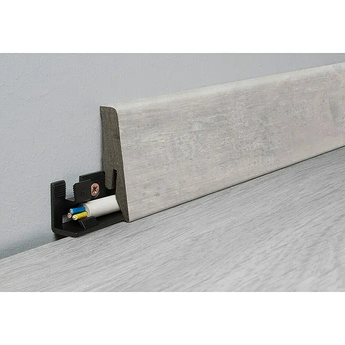 LOGOCLIC Sockelleiste Element Flex K58 C Vibe Tile - 260 cm x 18 mm x 58 mm, HDF, Vibe Tile - Eine Sockelleiste aus grauem Holz mit Kabelführung, die eine saubere und unauffällige Installation von Kabeln ermöglicht.