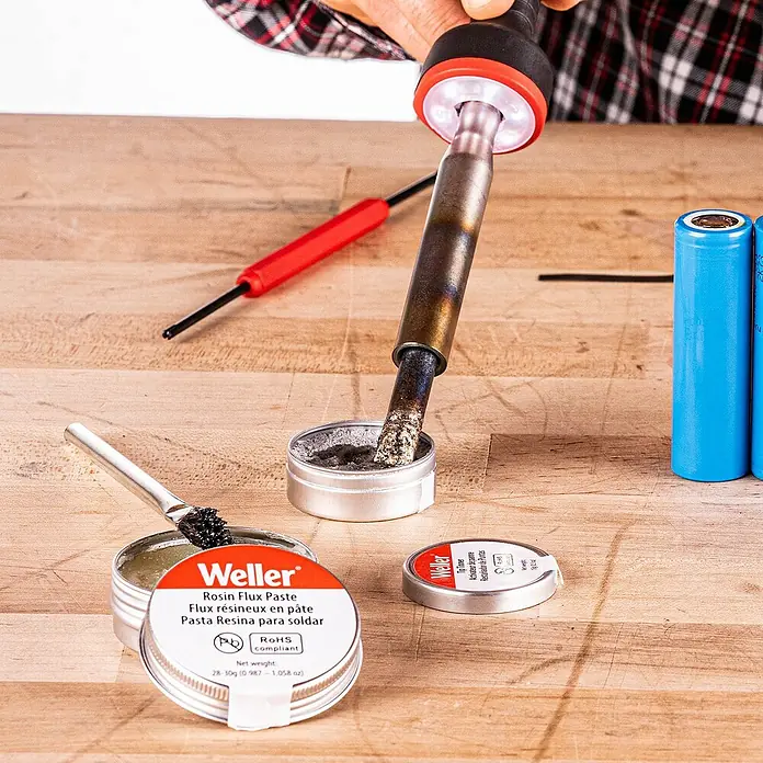 Weller Lötkolben-Set WLIRK6023C - 6 -tlg., Arbeitstemperatur: 427 °C, 60 W - Nahaufnahme eines Weller-Lötzinnflussmittel-Pastensets mit Lötkolben und weiterem Zubehör auf einem Holztisch.