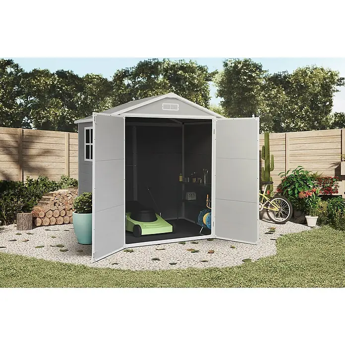 The Space Plus Gerätehaus One 2.56 - Außenmaß inkl. Dachüberstand (B x T): 181 x 134 cm, Kunststoff, Grundfläche: 2,39 m² - Ein graues Gartenhaus mit geöffneten Türen, in dem sich ein Rasenmäher befindet, umgeben von Grün.