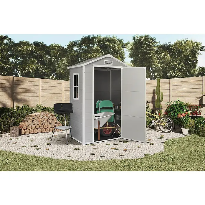 The Space Plus Gerätehaus One 1.36 - Außenmaß inkl. Dachüberstand (B x T): 134 x 103 cm, Kunststoff, Grundfläche: 1,37 m² - Ein graues Gartenhaus mit geöffneter Tür, in dem eine Schubkarre und ein grüner Klappstuhl stehen, steht im Garten.