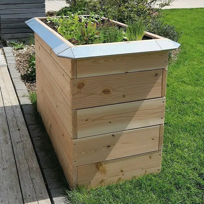 Bellissa Schneckenblech Eckteil - 21 x 10,5 x 3,5 cm - Ein hölzernes Hochbeet mit Metalleinfassung, bepflanzt mit verschiedenen Kräutern und Pflanzen, steht auf einem Rasen neben einem Holzweg.