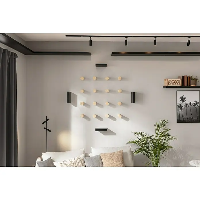 Regalux Wandboard XL4 - L x B x H: 23,5 x 118 x 3,8 cm, Schwarz, Belastbarkeit: 12 kg - Ein helles Wohnzimmer mit einer Wanddekoration aus runden Holzelementen, ergänzt durch moderne Regale und eine minimalistische Lampe.