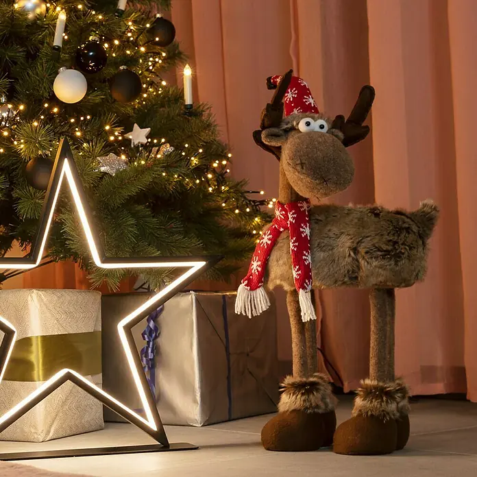 Dekofigur Elch mit Mütze - L x B x H: 35 x 15 x 53 cm, Kunststoff, Rentier - Weihnachtliche Szene mit einem niedlichen Elch, einem beleuchteten Stern und festlich verpackten Geschenken unter dem geschmückten Weihnachtsbaum.