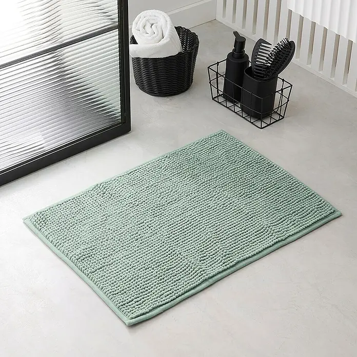 Badteppich Bubble - 40 x 60 cm, Blau, 100% Polyester - Ein mintgrüner, rechteckiger Badteppich mit Noppenstruktur liegt auf einem hellen Badezimmerboden neben einer Dusche und Badutensilien.