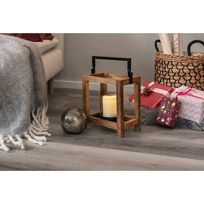 Dekoelement KugelDurchmesser: 10 cm, Glas, Braun - Einrichtungsszene mit einem Kerzenhalter aus Holz mit einem schwarzen Griff neben einem silbernen Dekoball und Weihnachtgeschenken.