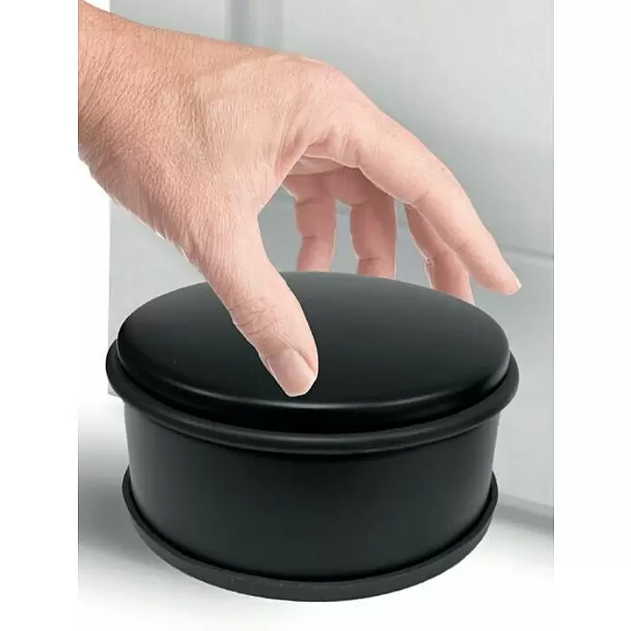 Walteco Bodentürstopper - Ø x H: 110 x 60 mm, Metall - Schwarzer, runder Türstopper mit Gummiringen, wird von einer Hand gedrückt.