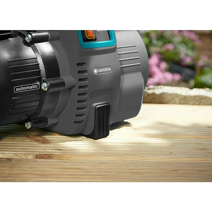 Gardena Hauswasserautomat 5000/5 LCD - 1.300 W, 5.000 l/h, 5 bar - Nahaufnahme einer Gardena-Gartenpumpe auf einem Holztisch, die für die Bewässerung und Wasserversorgung im Garten konzipiert ist.
