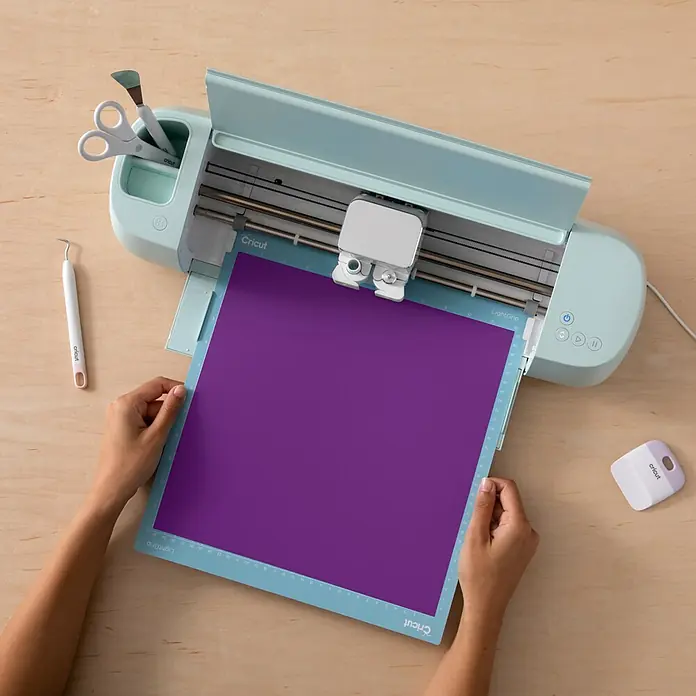 Cricut Vinylfolie Color Change Hot Permanent - 1 Stk., Lila/Türkis, 30 x 60 cm - Nahaufnahme einer Cricut Schneidemaschine mit lila Papier auf einer Schneidematte.