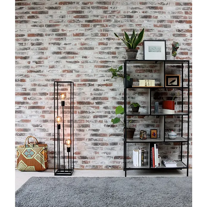 Celina Klinker Verblendstein Vintage Brooklyn - 5,2 x 24 cm, Rot/Weiß, Steinoptik - Ein modernes Wohnzimmer mit einem schwarzen Regal voller Pflanzen und Deko, einer Stehlampe und einem gewebten Korb auf einem grauen Teppich.