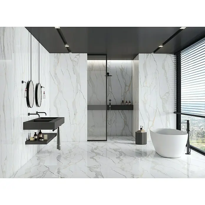 Feinsteinzeugfliese Calacatta Gold - 60 x 120 cm, Stärke: 9 mm, Weiß/Grau/Gold, Hochglänzend - Elegantes Badezimmer mit Marmorwänden, schwarzem Waschtisch und freistehender Badewanne unter einem Fenster mit Jalousien.