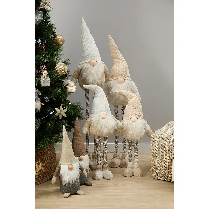 Figura decorativa Vaala - L x An x Al: 25 x 16 x 69 cm, Textil - Una escena festiva con un grupo de gnomos navideños de diferentes tamaños junto a un árbol de Navidad decorado.
