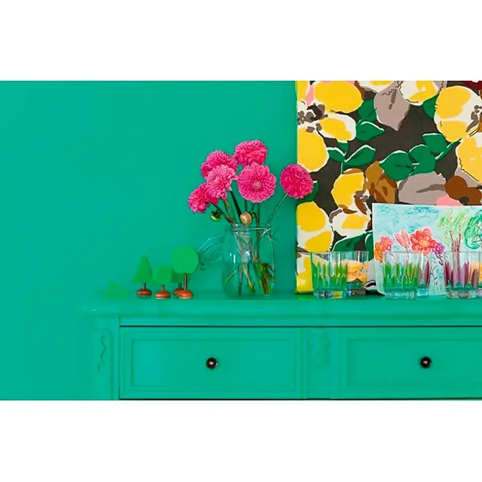 Bruguer Esmalte de color Acrylic multisuperficie - Verde primavera, Brillante, 750 ml, Base de agua - Vista de una cómoda verde con flores rosas en un jarrón, pequeños árboles y vasos pintados para un interior brillante y colorido.