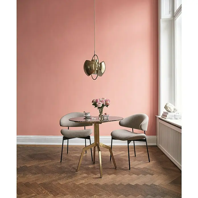 Alpina Wandfarbe Feine Farben - Kokette Sinnlichkeit, Matt, 2,5 l, Konservierungsmittelfrei - Stilvolles Esszimmer mit einem runden Tisch, zwei bequemen Stühlen und einer eleganten Pendelleuchte. Das Zimmer strahlt Wärme und Eleganz aus.