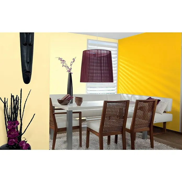 Alpina Vollton- & Abtönfarbe Color - Lucky Yellow, Matt, 750 ml, Lösemittelfrei - Esszimmer mit weißem Tisch, Holzstühlen, purpurroter Lampe, Blumen, Maske und gelben Wänden. Die stilvolle Einrichtung schafft eine gemütliche Atmosphäre.