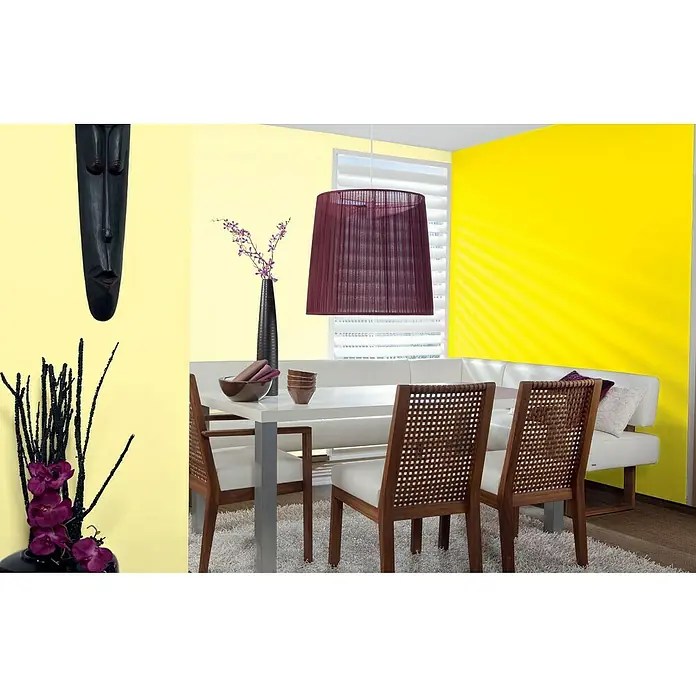 Alpina Vollton- & Abtönfarbe Color - Sunny Yellow, Matt, 250 ml, Lösemittelfrei - Das Bild zeigt ein Esszimmer mit einem Esstisch mit Stühlen, einer Lampe, einer Vase und einer Wanddekoration.