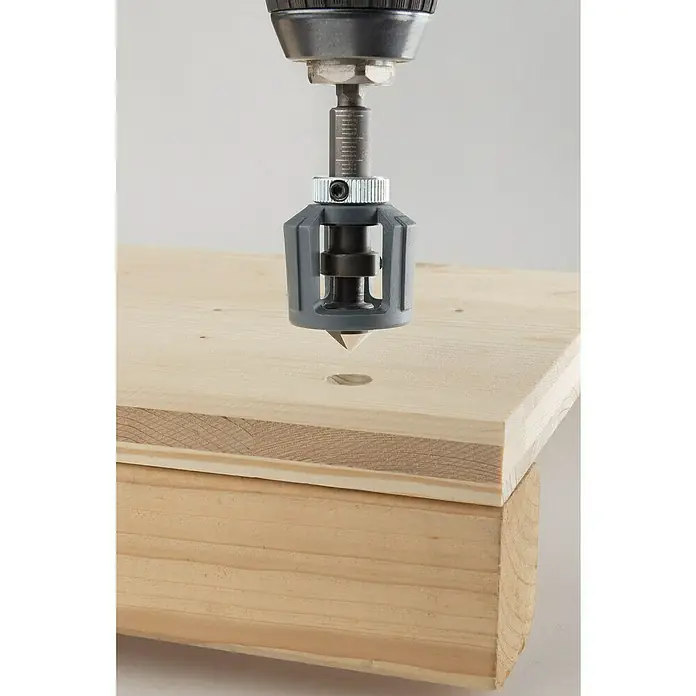 Wolfcraft Bithalter mit Tiefenstopp - Länge: 60 mm, ¼″ Sechskant - Eine Bohrmaschine mit einem Kegelsenkeraufsatz wird benutzt, um ein Loch in ein Stück Holz zu bohren. Das Werkzeug ist präzise und effizient.
