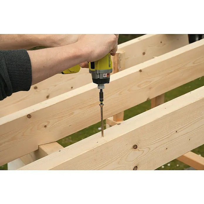 Wolfcraft Bit-Box Torx - 7 -tlg. - Ein gelber Akkuschrauber wird benutzt, um eine lange Schraube in einen Holzbalken zu schrauben, um die Konstruktion zu befestigen.