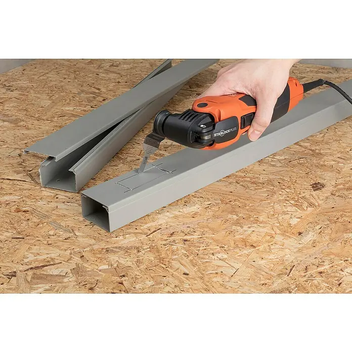 Wolfcraft Tauchsägeblatt Expert BiM - Arbeitsbreite: 10 mm - Eine Person schneidet mit einem oszillierenden Multifunktionswerkzeug ein Loch in eine graue Kabelkanalabdeckung auf einer Holzoberfläche.