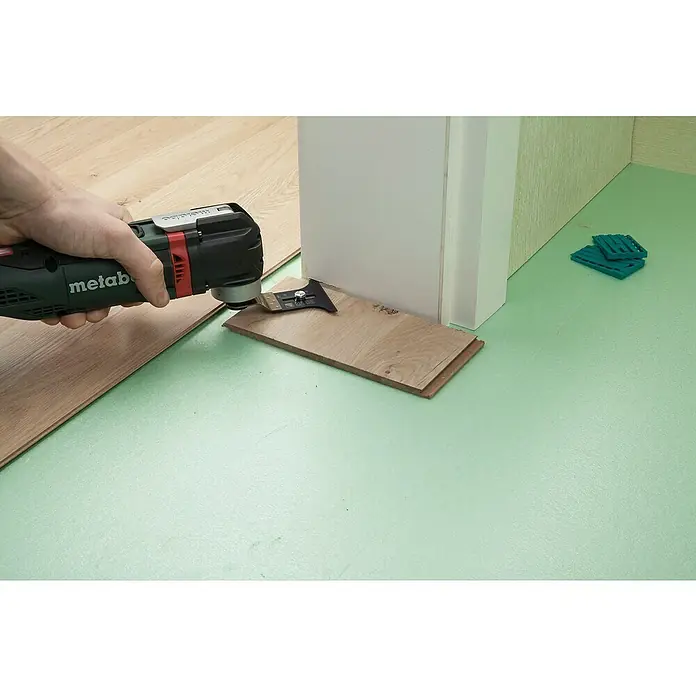 Wolfcraft Tauchsägeblatt Pro mit Tiefenanschlag - 65 mm, 1 Stk. - Das Bild zeigt eine Metabo Multifunktionswerkzeug beim Kürzen einer Holztürleiste, für präzise Holzarbeiten.