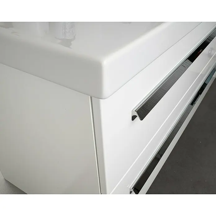 Lanzet K1 Waschtischunterschrank59,2 x 44,3 x 48,3 cm, Berg Eiche - Detailaufnahme eines weißen Badezimmerschranks mit Schubladen und verchromten Griffen. Elegantes Design für ein modernes Badambiente.