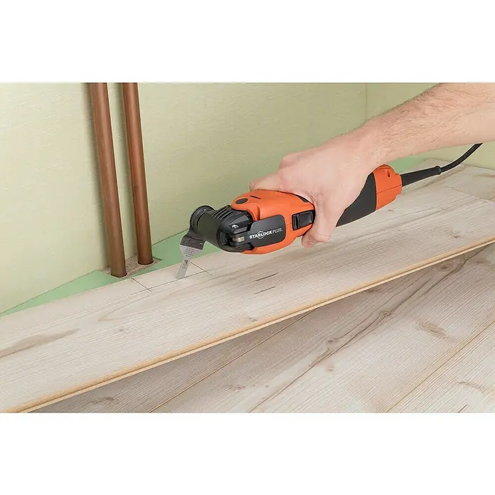 Wolfcraft Tauchsägeblatt Expert BiM - Arbeitsbreite: 10 mm - Nahaufnahme eines oszillierenden Multifunktionswerkzeugs Starlock Plus beim Schneiden eines Lochs in eine Holzbodenplanke.