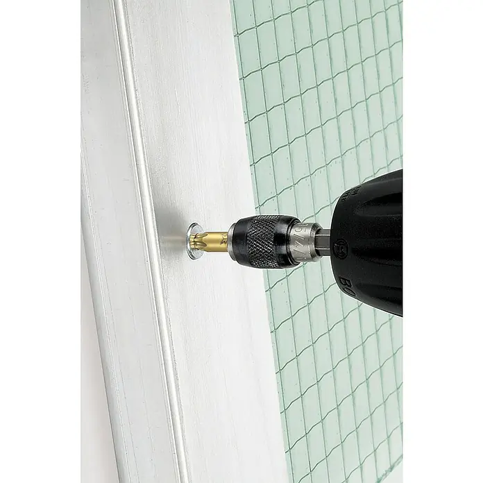 Wolfcraft Diamant-Bit - TX 10 - Ein Schraubendreher wird verwendet, um eine Schraube in ein weißes Bauteil zu schrauben, um es zu befestigen, während eine grüne Glasmatte im Hintergrund sichtbar ist.