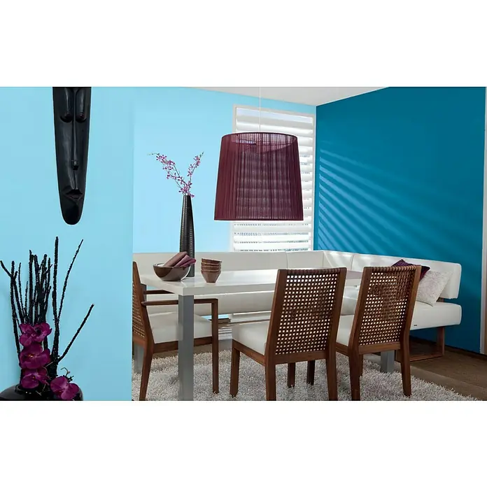 Alpina Vollton- & Abtönfarbe Color - Cool Blue, Matt, 250 ml, Lösemittelfrei - Stilvolles Interieur mit modernem Esstisch, Stühlen mit Rattangeflecht und dekorativer Beleuchtung, die eine warme und einladende Atmosphäre schaffen.