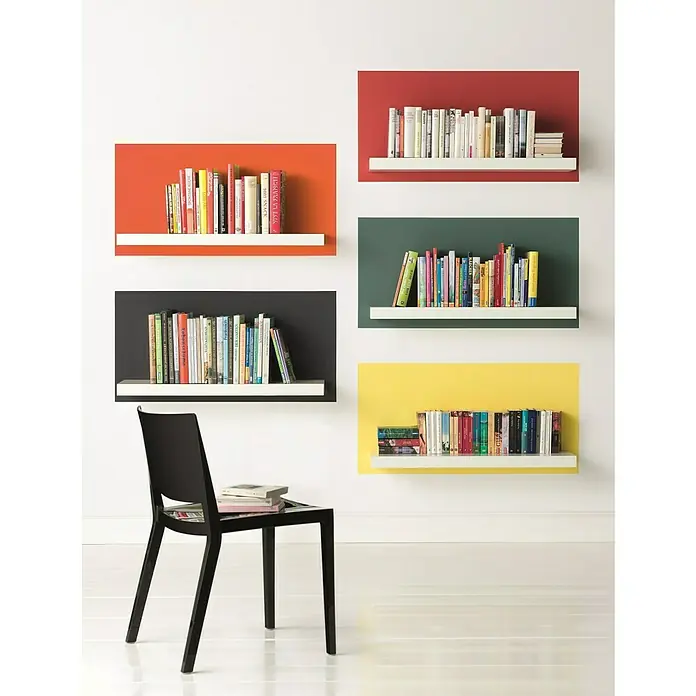Alpina Vollton- & Abtönfarbe Color - Happy Orange, Matt, 250 ml, Lösemittelfrei - Buntes Bücherregal mit einem eleganten schwarzen Stuhl, der dem Raum einen modernen Touch verleiht. Die Bücher sind ordentlich aufgereiht.