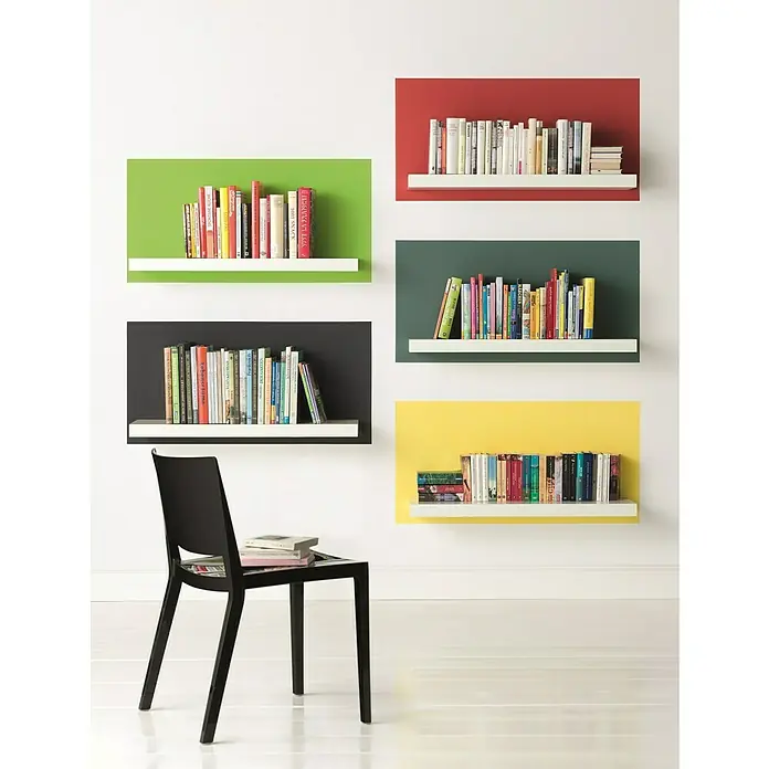 Alpina Vollton- & Abtönfarbe Color - Power Green, Matt, 250 ml, Lösemittelfrei - Wandregale mit bunten Hintergründen und Bücher darauf, darunter ein schwarzer Stuhl mit Büchern.