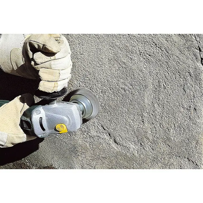 Wolfcraft Topfbürste - Durchmesser: 90 mm, Stahldraht - Nahaufnahme eines Arbeiters, der mit einem Winkelschleifer eine Betonoberfläche bearbeitet, wobei Schutzkleidung getragen wird.