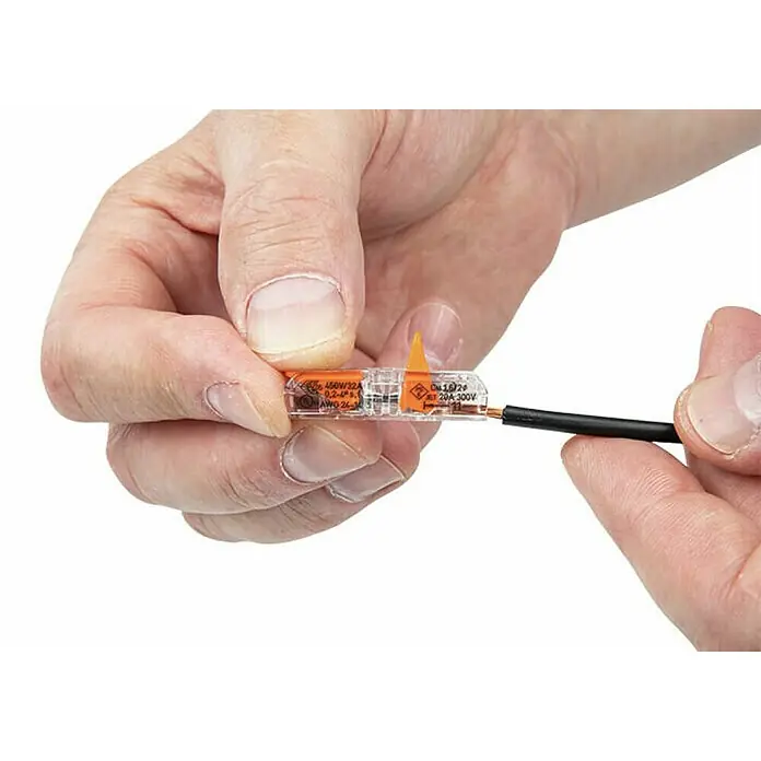 Wago Durchgangsklemme 221-2411 mit Hebeln12 Stk., 0,2 mm² - 4 mm² - Eine Nahaufnahme von Händen, die einen Wago-Kabelverbinder mit einem schwarzen Draht halten.