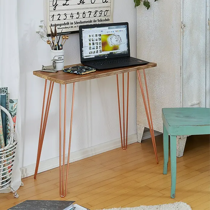 Wagner System Möbelfuß Hairpinlegs - Stahl, Höhe: 71 cm, Rosé Gold - Ein minimalistischer Schreibtisch mit einer Holzplatte und kupferfarbenen Metallbeinen, darauf ein Laptop und Schreibutensilien.