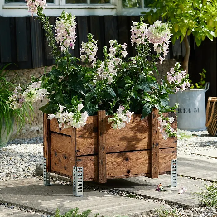 Wagner System Möbelfuß - Höhe: 12 cm, Stahl, Silber - Ein rustikaler Blumenkasten aus Holz mit zarten, weißen Blüten steht auf einem gepflasterten Untergrund im Garten.