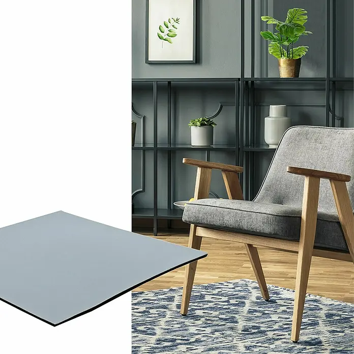Wagner System Möbelgleiter - L x B x H: 100 x 100 x 1,5 mm, Kleben, 1 Stk. - Ein modernes Interieur mit einem hellgrauen Tisch mit schwarzem Rand, einem bequemen Sessel und einem stilvollen Bücherregal im Hintergrund.
