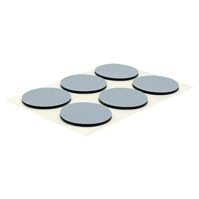 Wagner System Möbelgleiter - Durchmesser: 25 mm, Kleben, 12 Stk., Kunststoff - Sechs runde Möbelgleiter mit grauer Oberfläche und schwarzer Schaumstoffunterlage auf einer weißen Trägerfolie.
